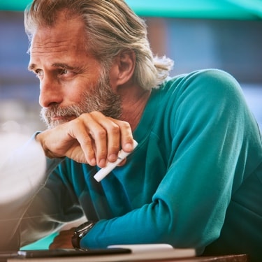 Hombre con dispositivo IQOS blanco en la mano