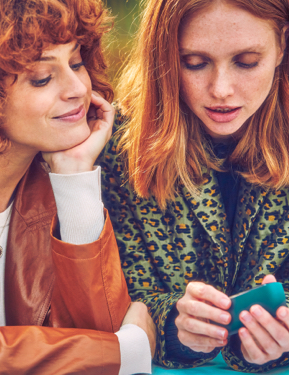 Dos mujeres mirando un dispositivo IQOS.