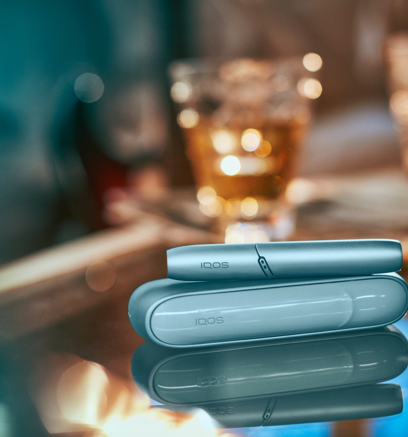 Dispositivo IQOS Original DUO en turquoise sobre mesa brillante.