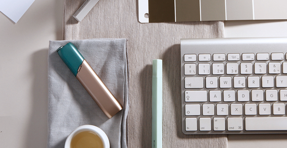Kit IQOS 3 MULTI verde y cobre sobre una mesa de trabajo