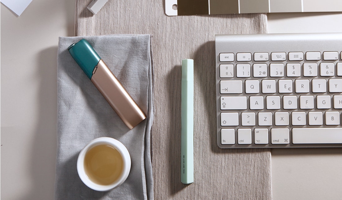 Kit IQOS 3 Multi verde y cobre sobre una mesa de trabajo