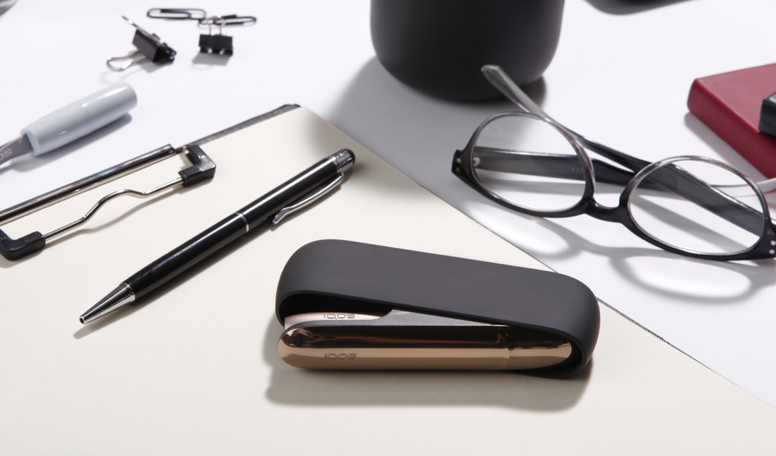 Kit IQOS 3 negro y plata sobre una mesa de trabajo
