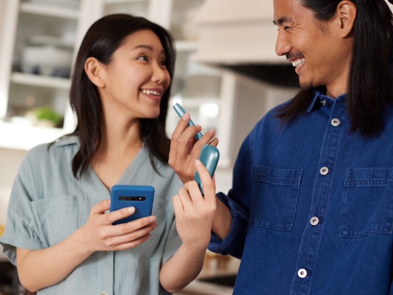 Dispositivo IQOS Originals sostenido por una pareja sonriente