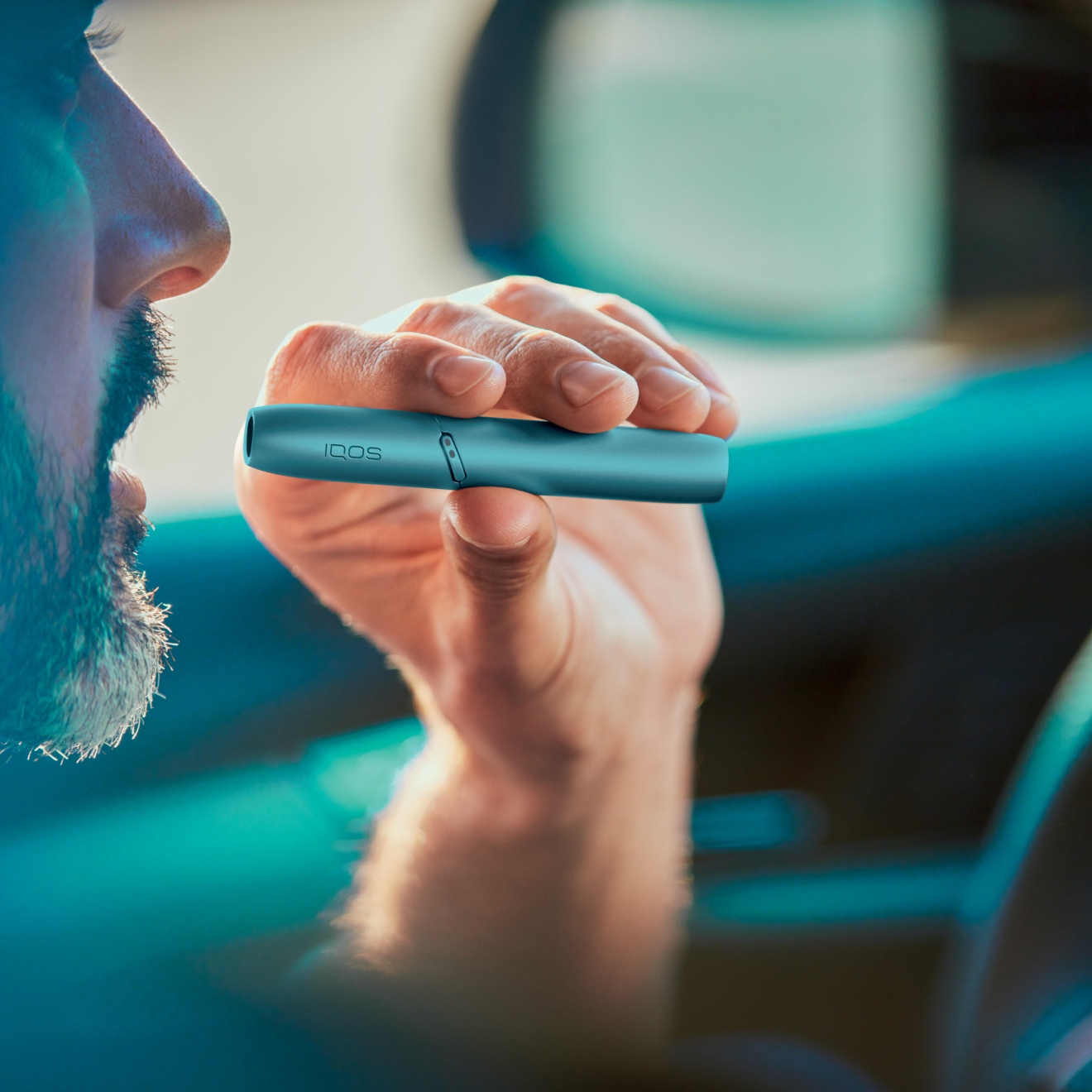 Hombre sosteniendo un Holder de IQOS Originals Duo en el carro