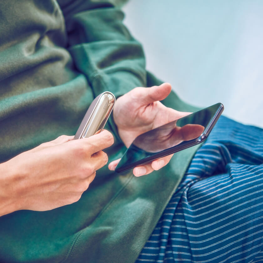 Una persona registra en línea su dispositivo IQOS en su celular	 	 	 	