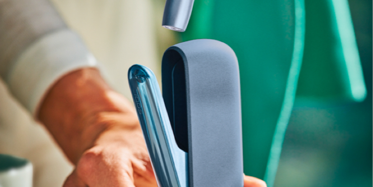 Una persona colocando un Pocket Charger IQOS ILUMA en una base de carga