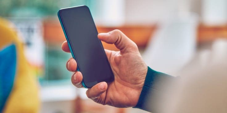 Una persona sostiene un teléfono celular.