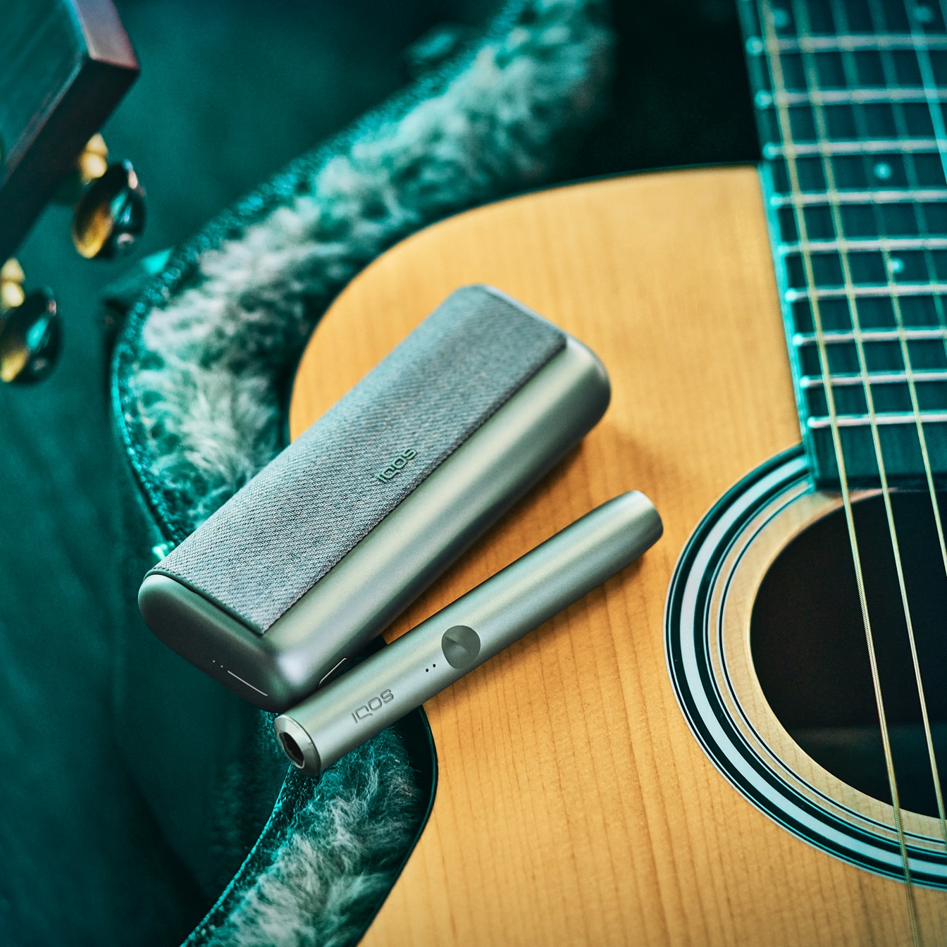 An IQOS ILUMA PRIME device on a guitar.